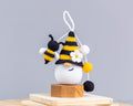 Crochet bee gnome keychain standing on table