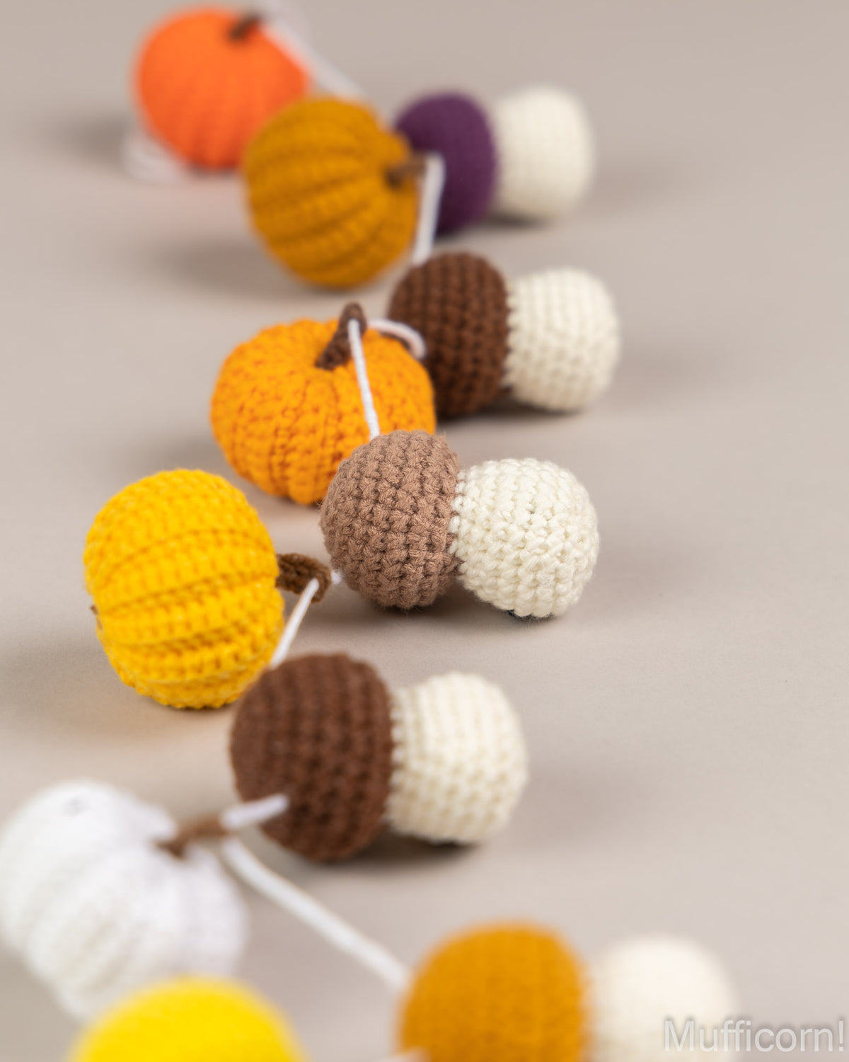 Close-up crochet pumpkin and mushroom garland stitch detail