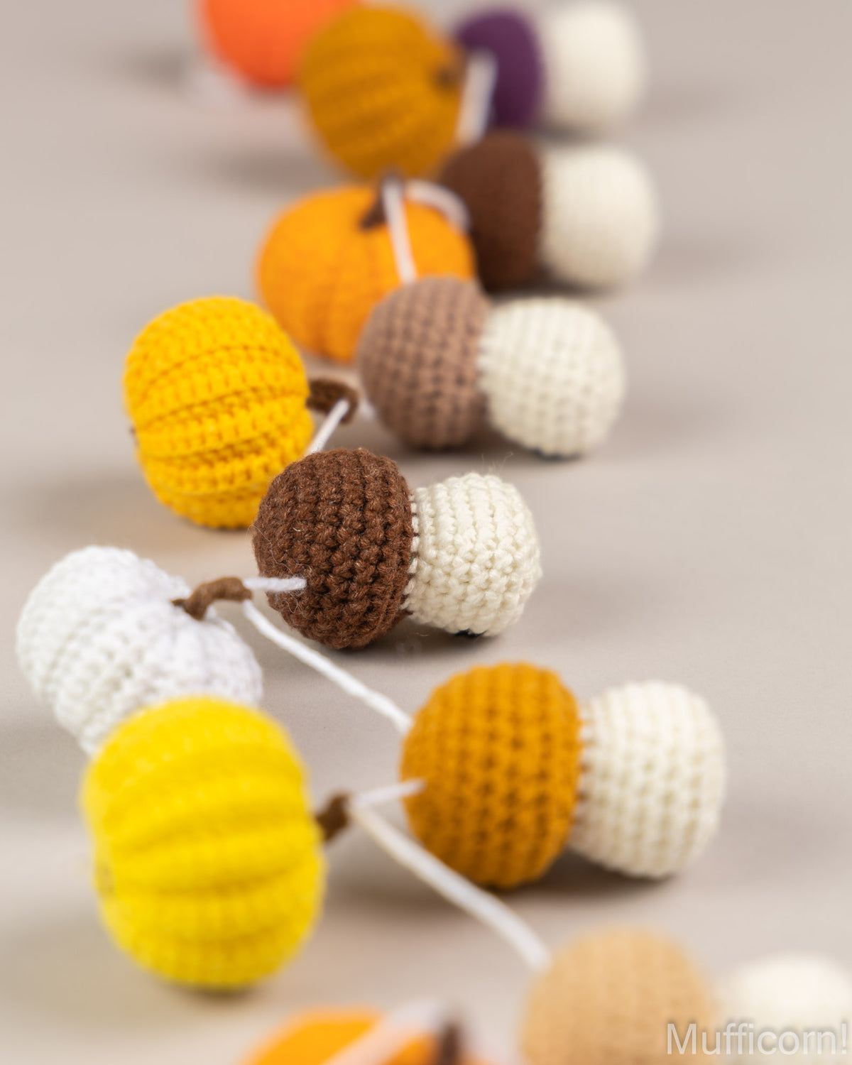 Crochet pumpkin and mushroom garland laying on table