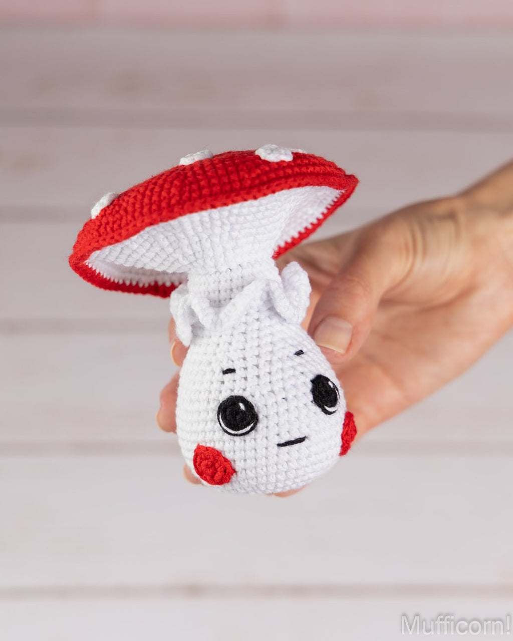 Mushroom boy crochet pattern held in hand