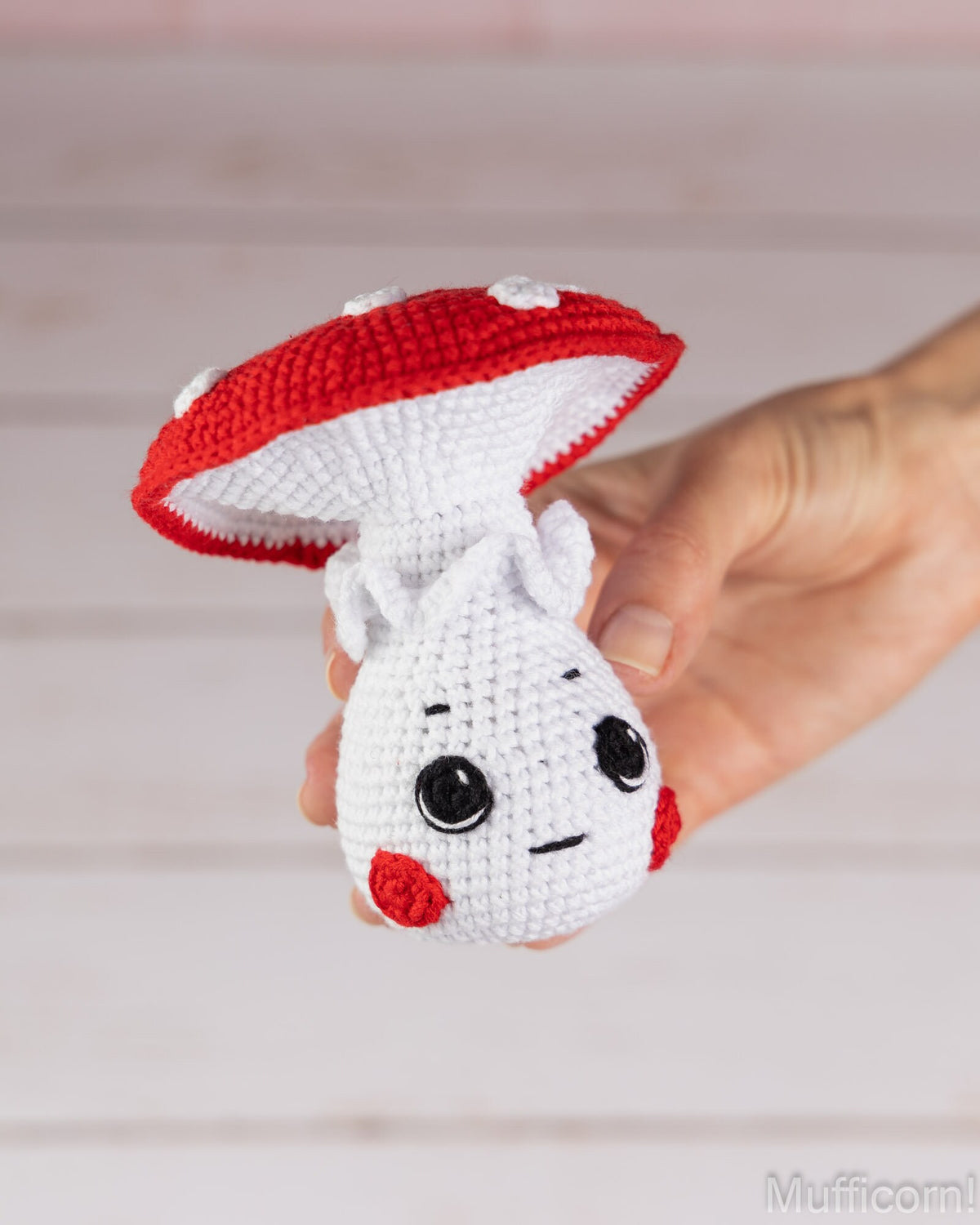 Mushroom boy crochet pattern held in hand