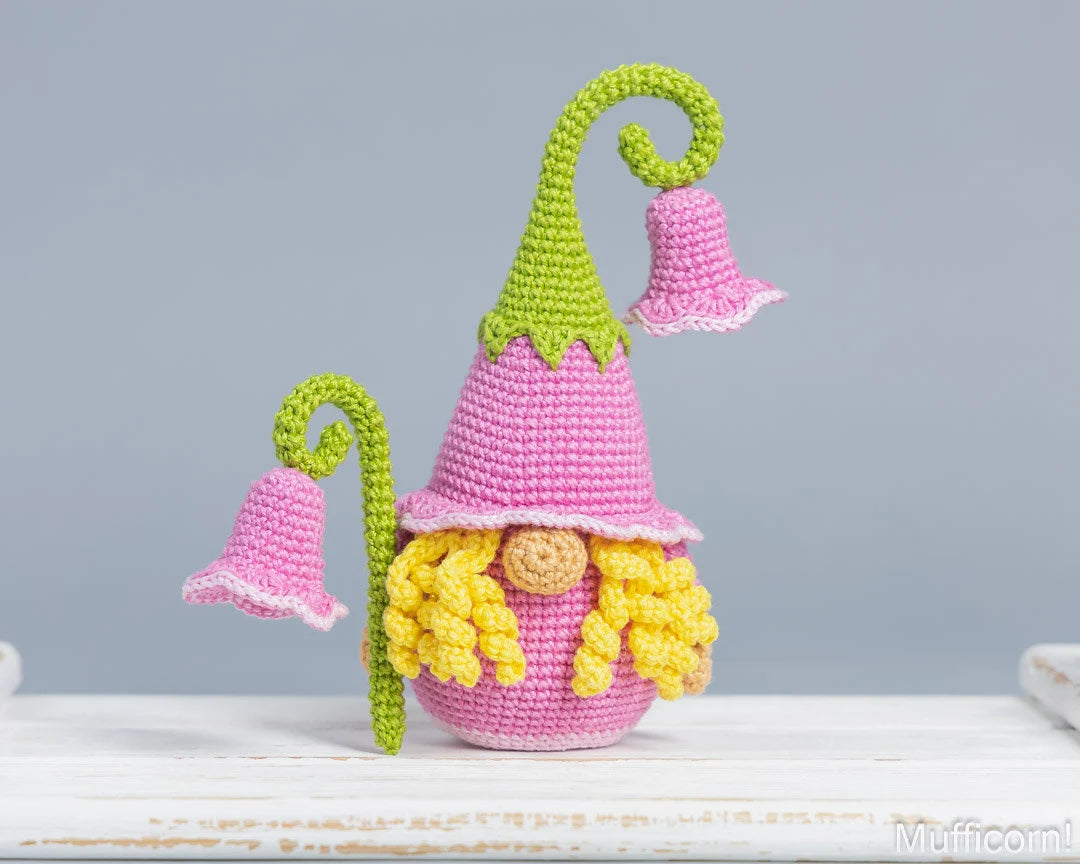 Crochet flower gnome girl with campanula and yellow curly hair on the tray
