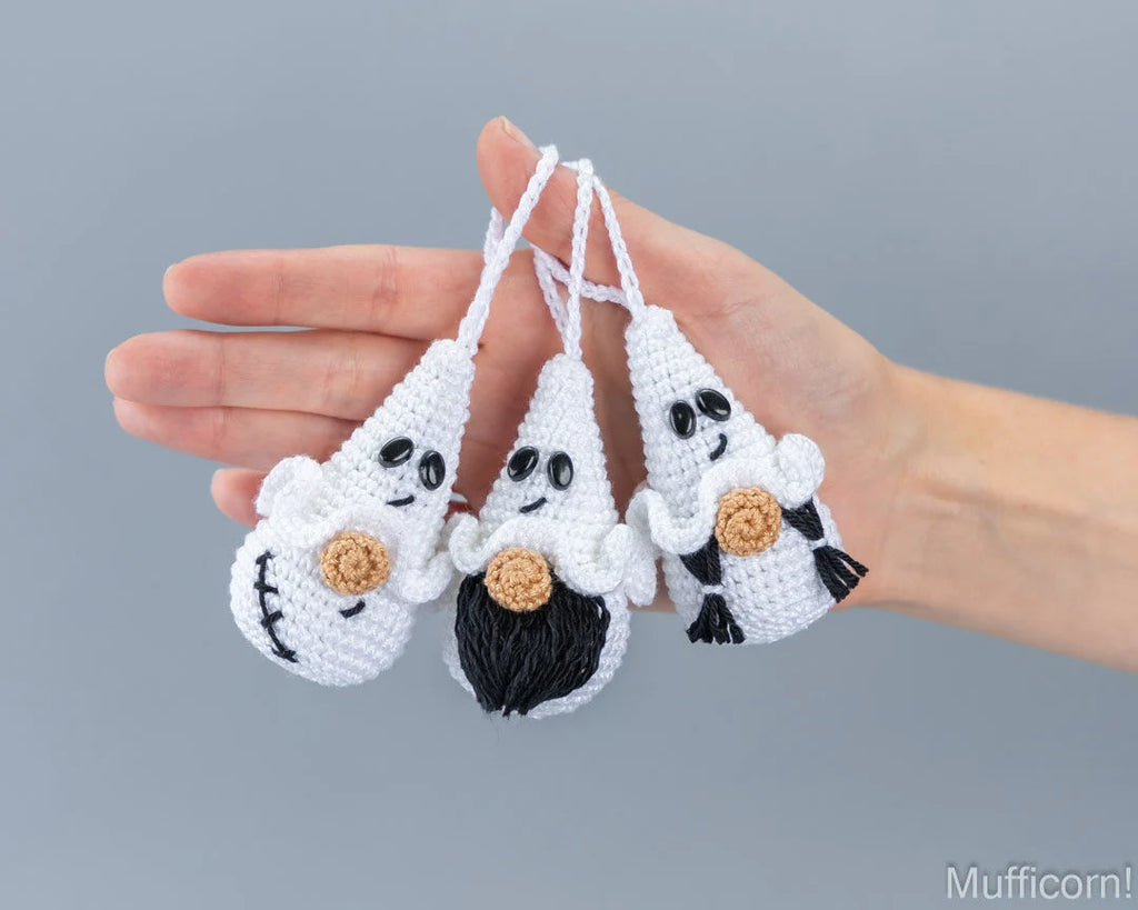 Three Halloween ghost gnome keychains hanging in hand