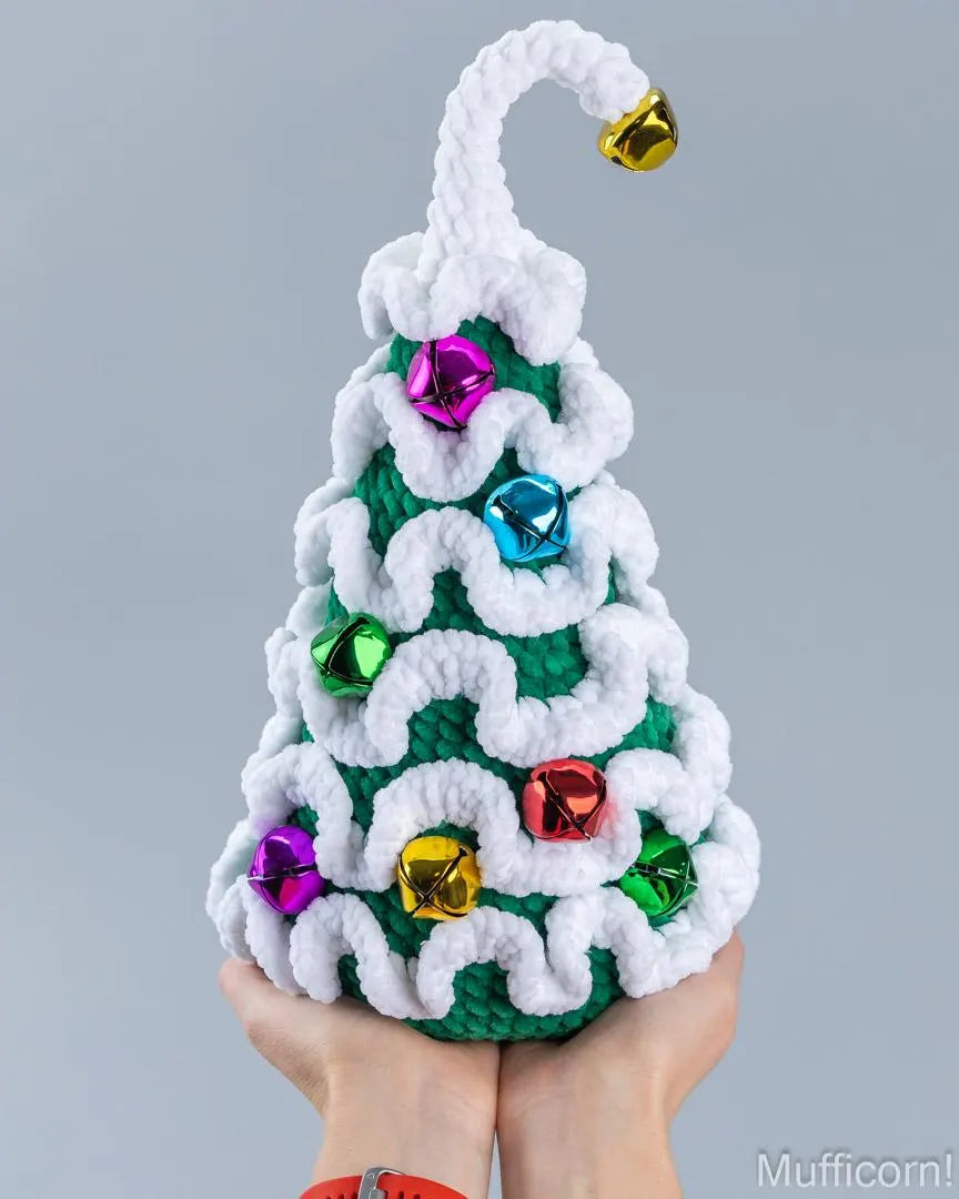 Plush crochet Christmas tree with bells held in two hands