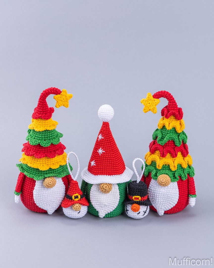 Four crocheted Christmas gnome ornaments in different sizes, featuring colorful striped tree hats, Santa hats, and a snowman hat, arranged on a light gray background.