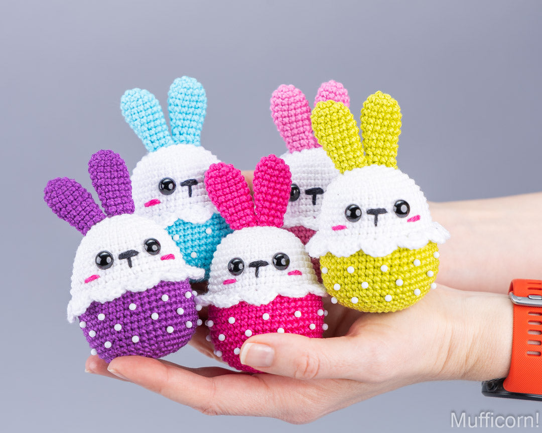 Five crochet Easter bunnies in different colors held in hand