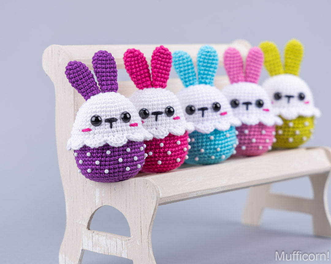 Five crochet Easter bunnies sitting on bench