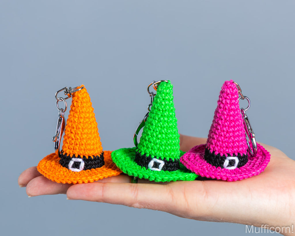Orange, green, pink witch hat keychaind on the hand